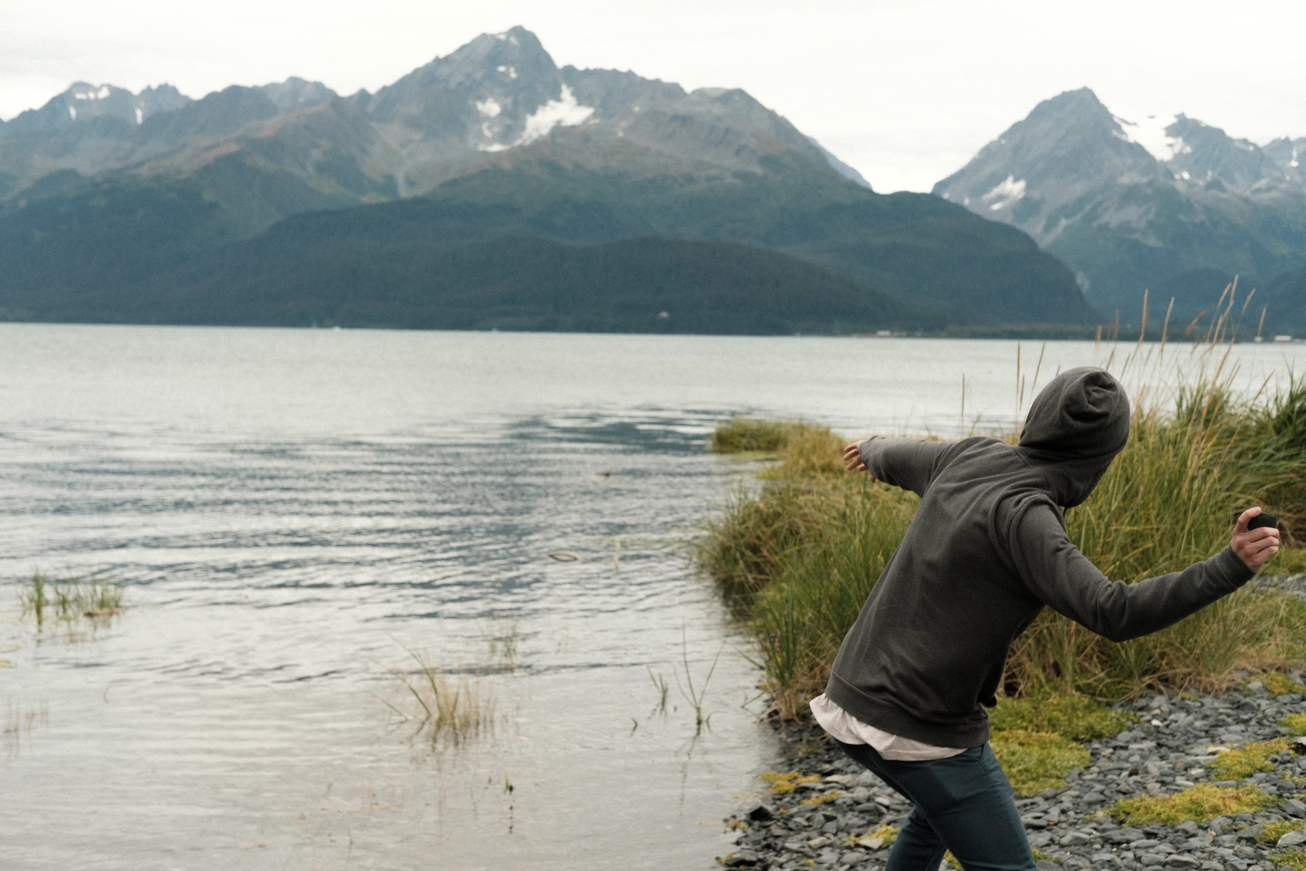 Young man skipping rocks