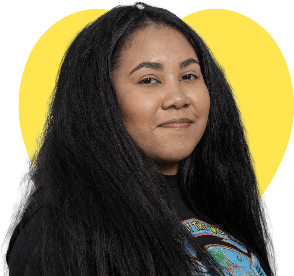 A young mother wearing a plaid shirt looking at the camera.