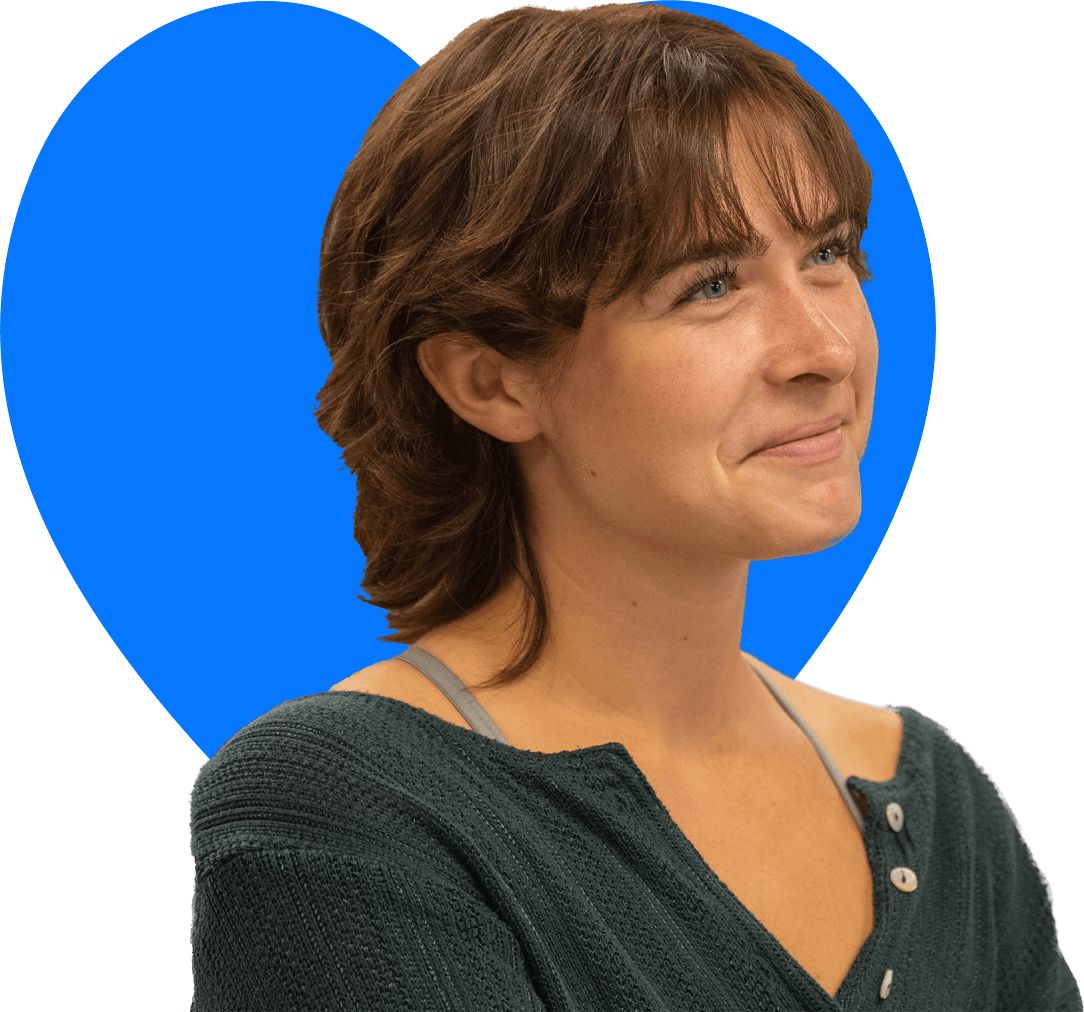 A woman working with a mixing bowl wearing an apron with the Covenant House Alaska logo